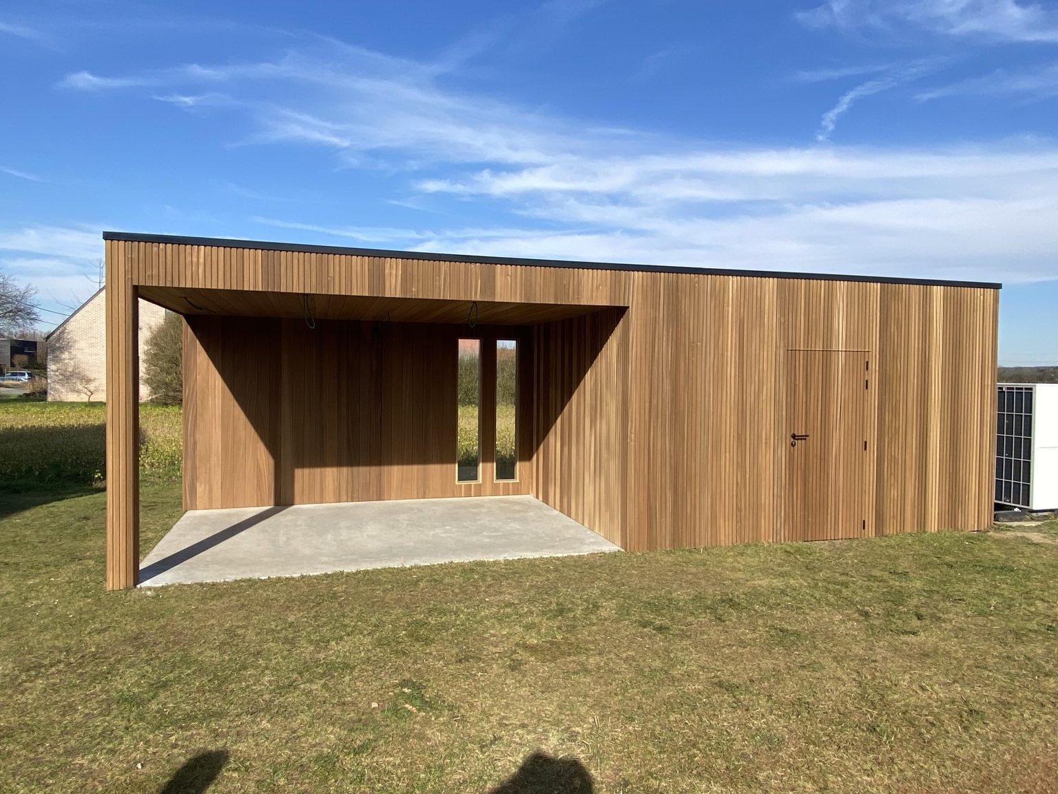 strakke tuinberging met houten verticale stroken en overkapping